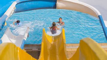 Una piscina con un tobogán amarillo y una persona dentro.