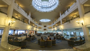 Een ruime atrium met een centraal open gedeelte, meerdere niveaus en een grote dakkoepel.