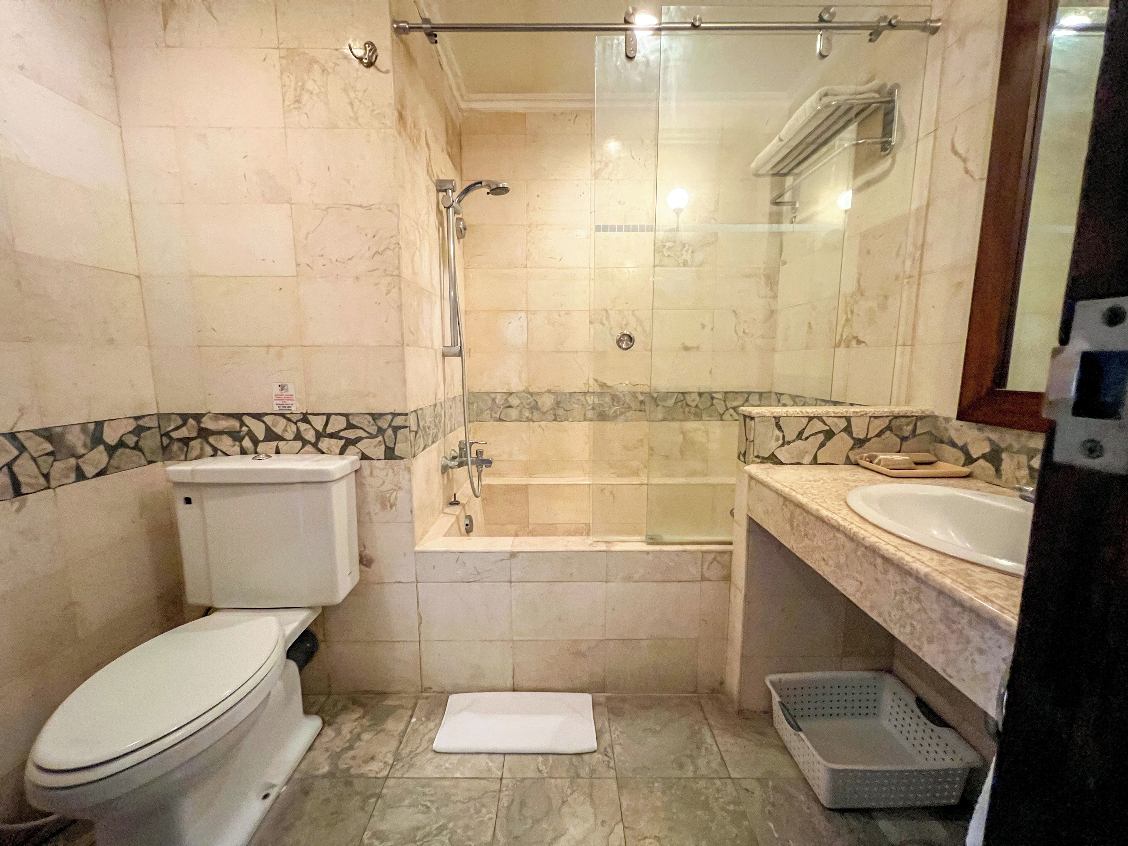 A bathroom with a toilet, a bathtub, and a shower.