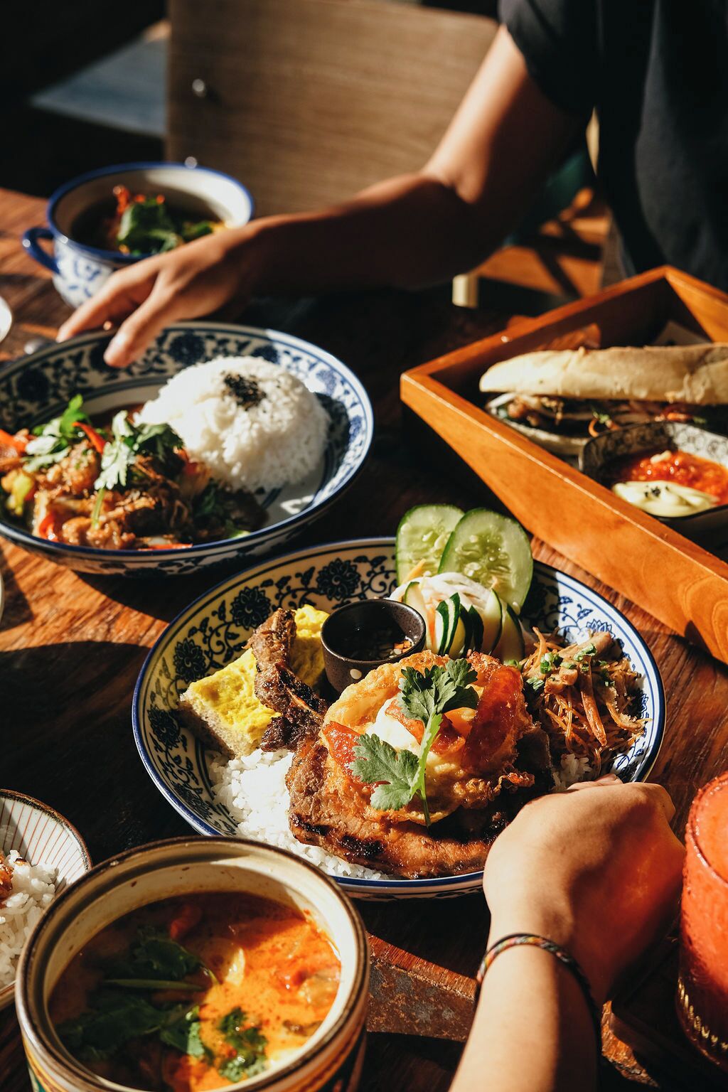 A dining table with various dishes, including rice, meat, and vegetables, suggesting a meal setting.
