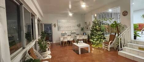 Un salón espacioso con piso de madera, un comedor, una escalera y un árbol de Navidad decorado.