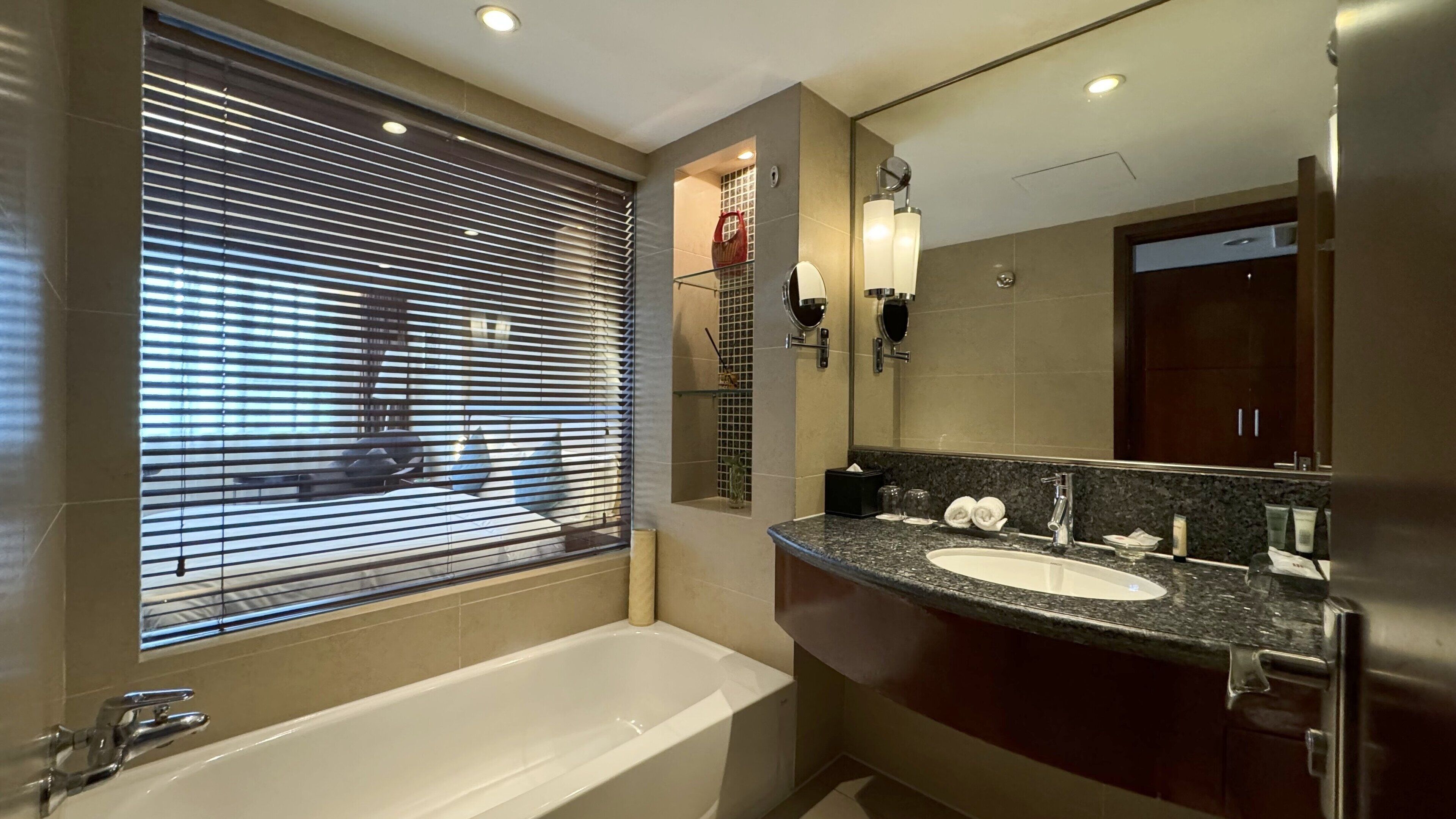 A modern bathroom with a bathtub, a sink, and a large mirror.