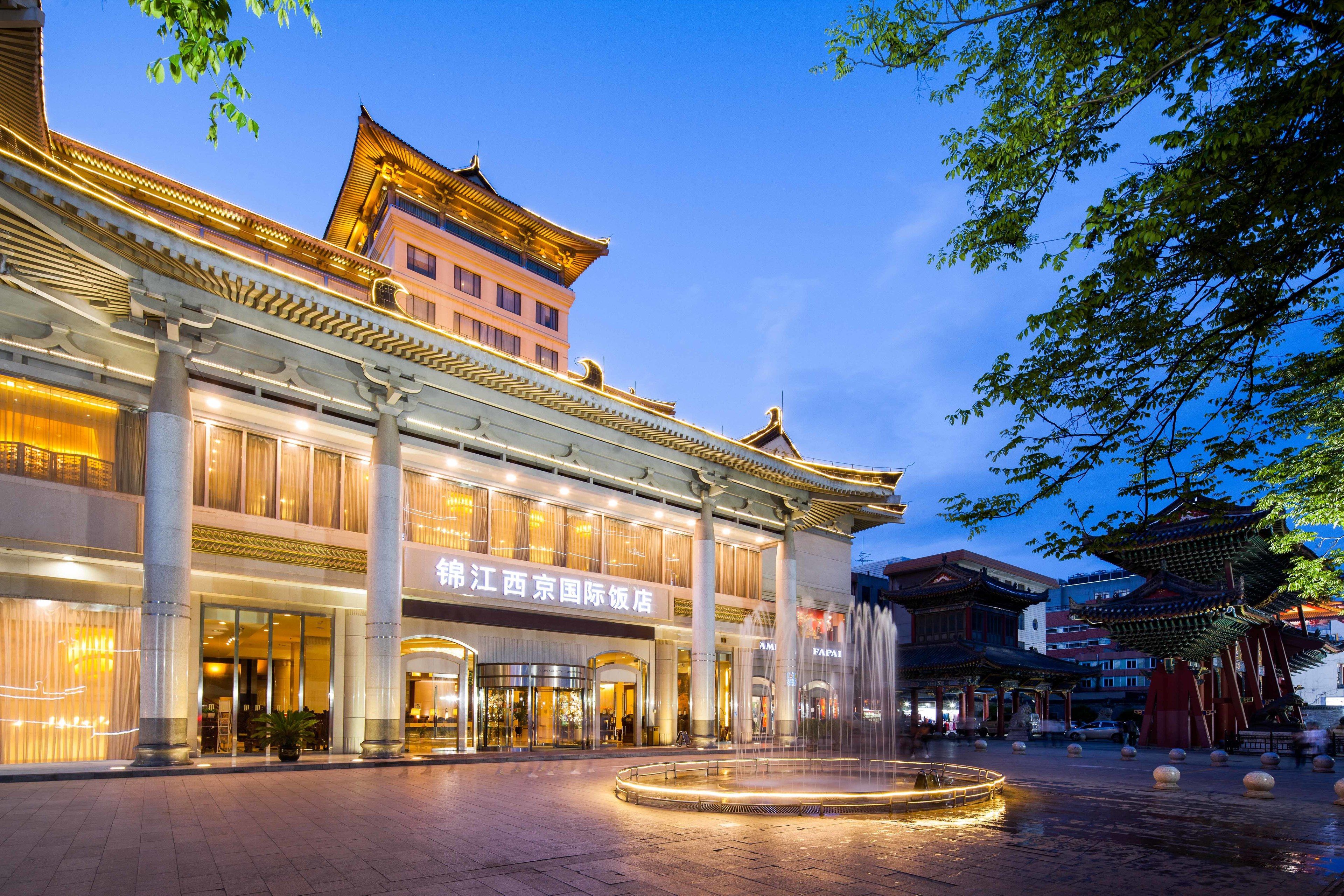 A traditional building with a large entrance and a fountain in the courtyard.