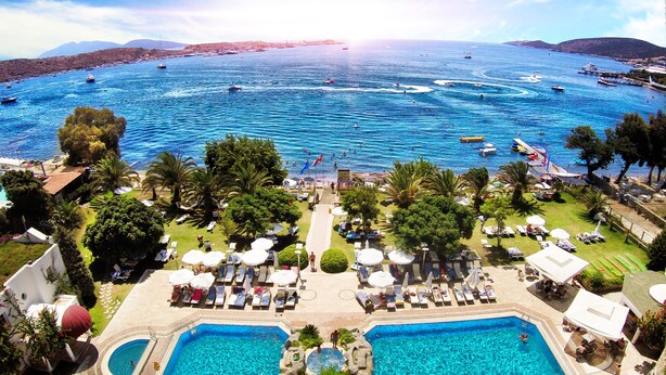A resort with a large swimming pool, sun loungers, and a view of the sea. - Royal Asarlik Beach Hotel & Spa - All Inclusive (Bodrum)