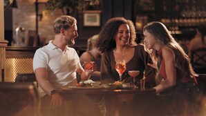 A bar setting with a table, glasses, and a person. - The Wordsworth, Grasmere- The Inn Collection Group (Ambleside)