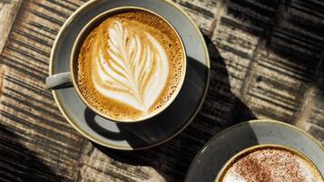 Una taza de café con arte de latte sobre una mesa de madera.