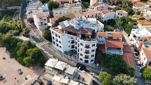 A multi-story hotel with balconies, a beachside location, and a parking area. - BUE MARINO HOTEL & ROOFTOP BAR (Dorgali)