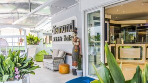 A modern hotel lobby with a large sign reading "Diamond Hotel," a mannequin dressed in traditional attire, and various potted plants. - Hotel Diamond (Riccione)