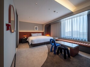 A modern hotel room with a large bed, a desk, a chair, and a window with a city view. - ENFORD Hotel (Cheongju)