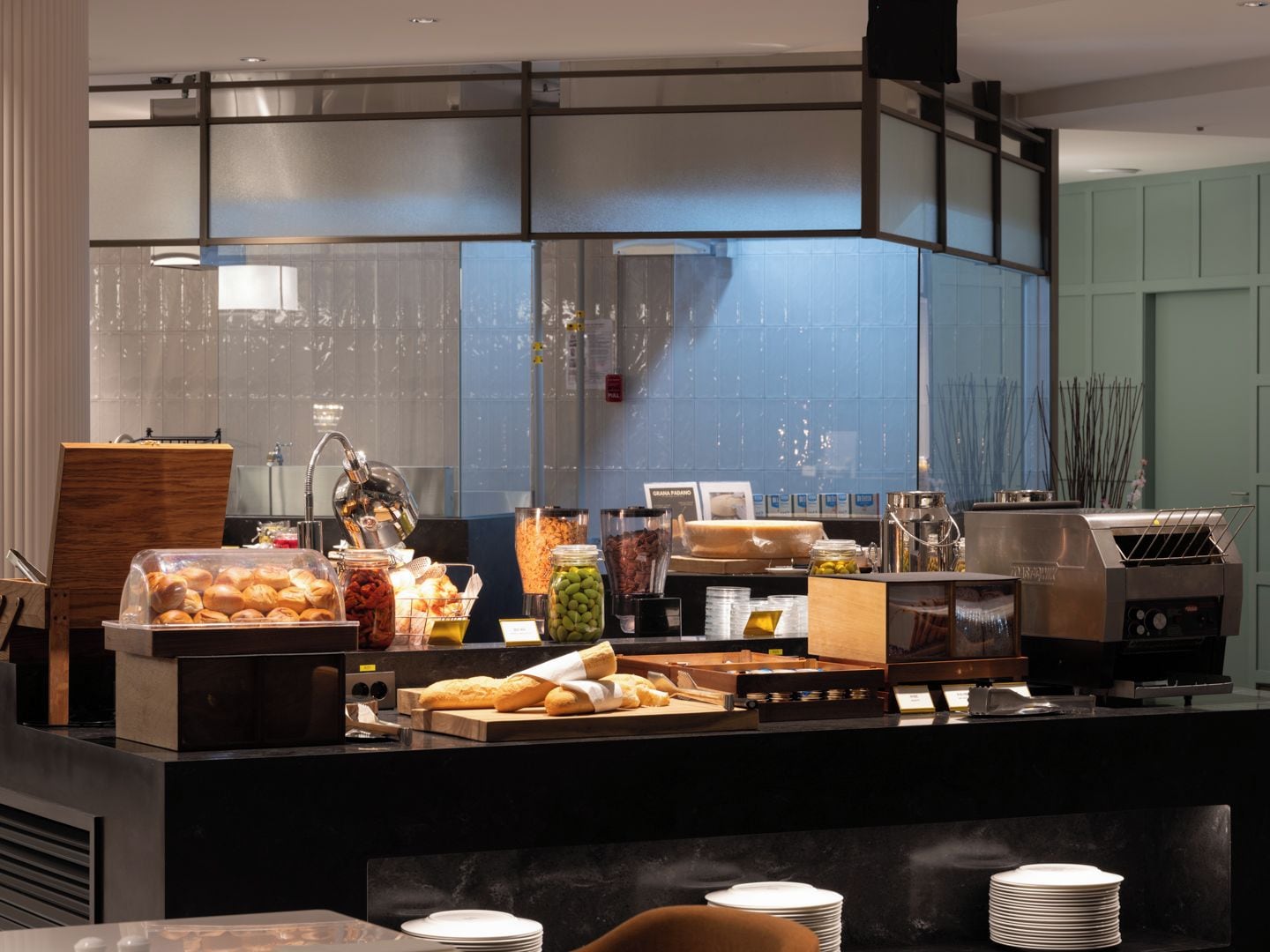 A buffet counter with various food items, a coffee machine, and a grill.