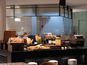 A buffet counter with various food items, a coffee machine, and a grill. - ENFORD Hotel (Cheongju)