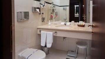 A modern bathroom with a toilet, sink, and mirror.