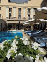 Una piscina al aire libre, sillones reclinables de piscina
