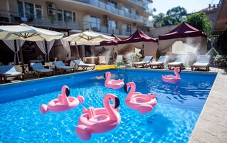Una piscina al aire libre, sillones reclinables de piscina