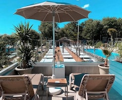 Een buitenzwembad, ligstoelen bij het zwembad