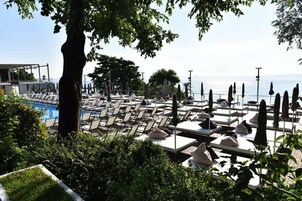 Una playa cerca, sillas reclinables de playa, sombrillas