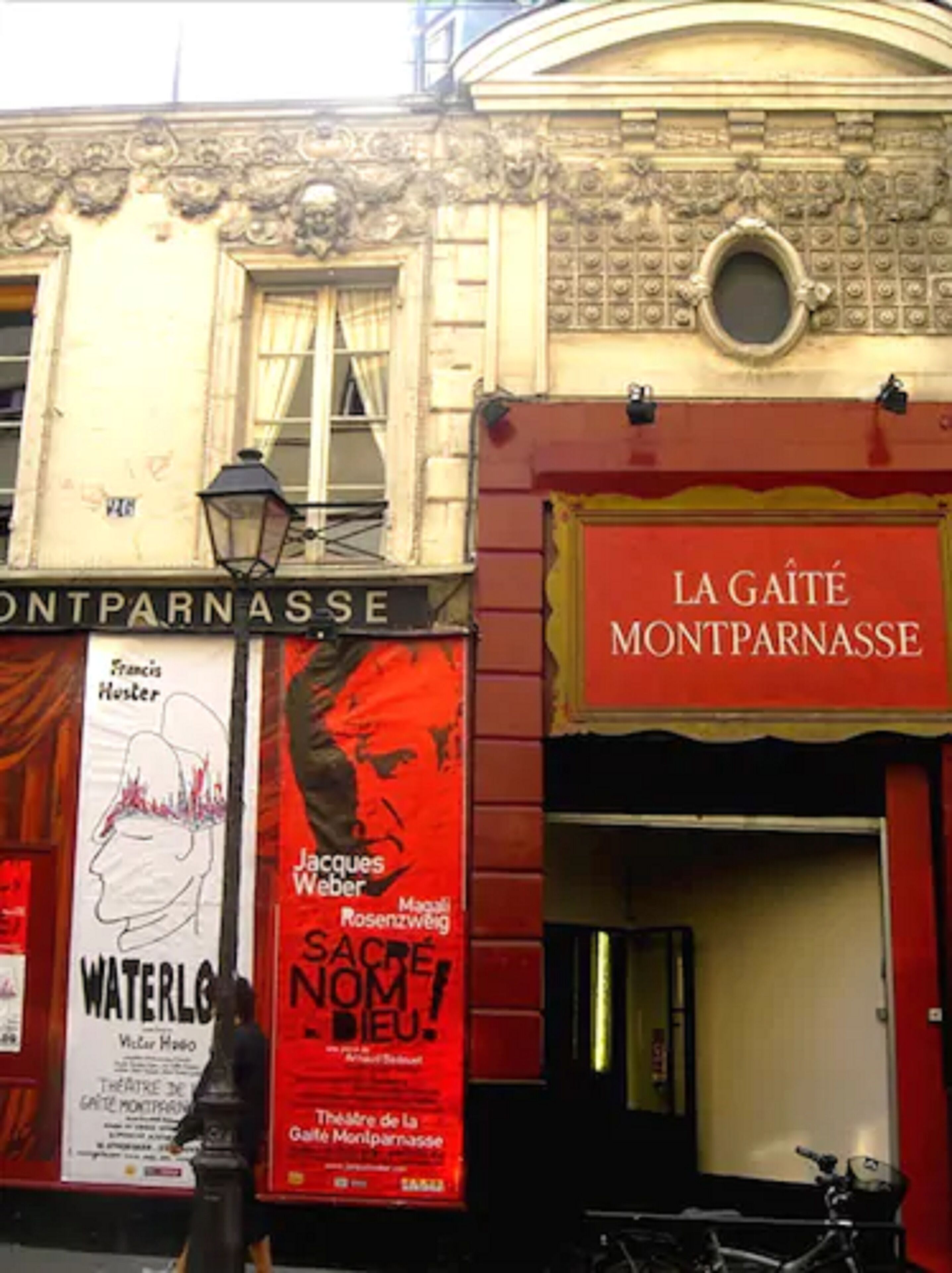 A building facade with the sign 'LA GAÎTE MONTPARNASSE' and multiple posters advertising events.