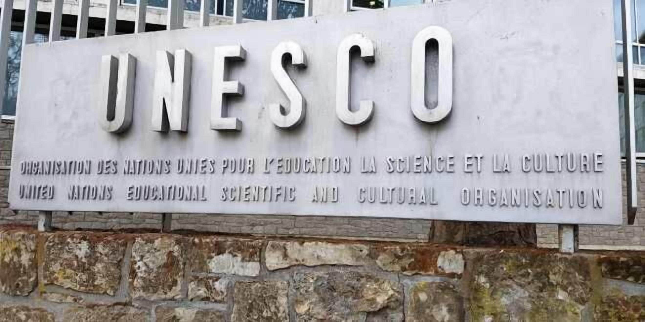 A sign for UNESCO with the organization's name and mission statement.