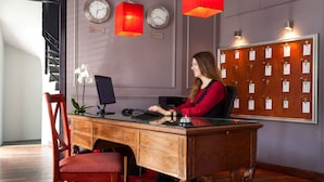 A wooden desk with a computer, a red chair, and a clock on the wall. - Eiffel Villa Garibaldi (Paris)