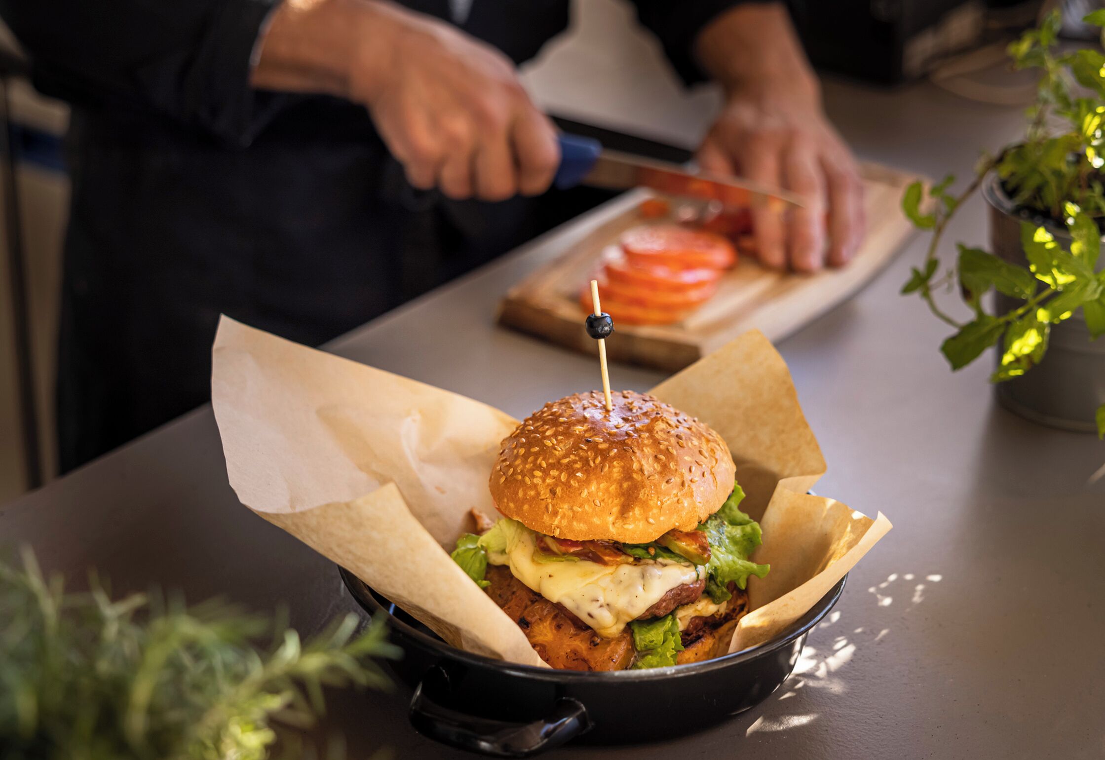 Ein Burger in einer schwarzen Gusseisenpfanne auf einem Tisch.