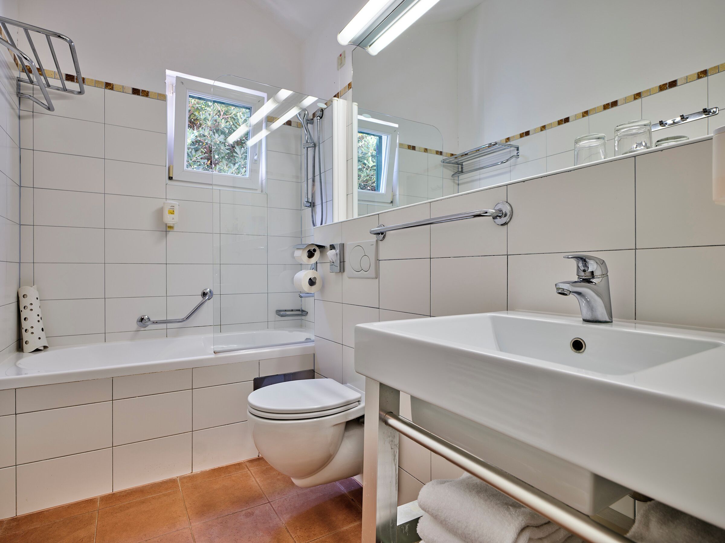 A modern bathroom with a bathtub, toilet, and sink.
