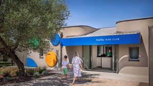 Un edificio con un toldo azul que dice "MaiSky Kids Club".