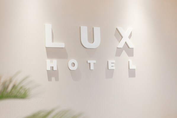 Una pared con las palabras "LUX HOTEL" en letras blancas.