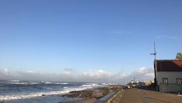 Uma passarela costeira com vista para o mar e um edifício com telhado vermelho.