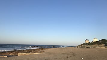 Una playa cerca, arena blanca, camas de playa, vóleibol de playa