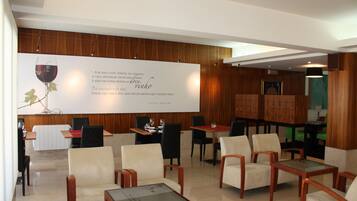 A modern dining area with wooden paneling, comfortable seating, and a large menu board.