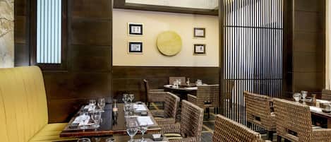 Un restaurante con muebles de madera, cuadros enmarcados en la pared y una mesa redonda en el centro.