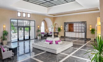 A spacious lobby with a central seating area, large windows, and a reception desk.