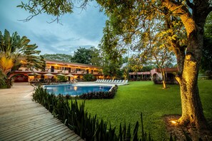 Una piscina al aire libre, sombrillas, sillones reclinables de piscina