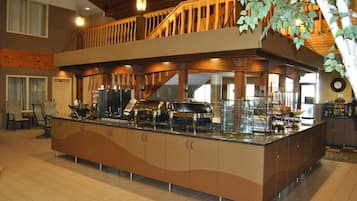 A spacious kitchen with a central island, wooden upper deck, and a clock on the wall.
