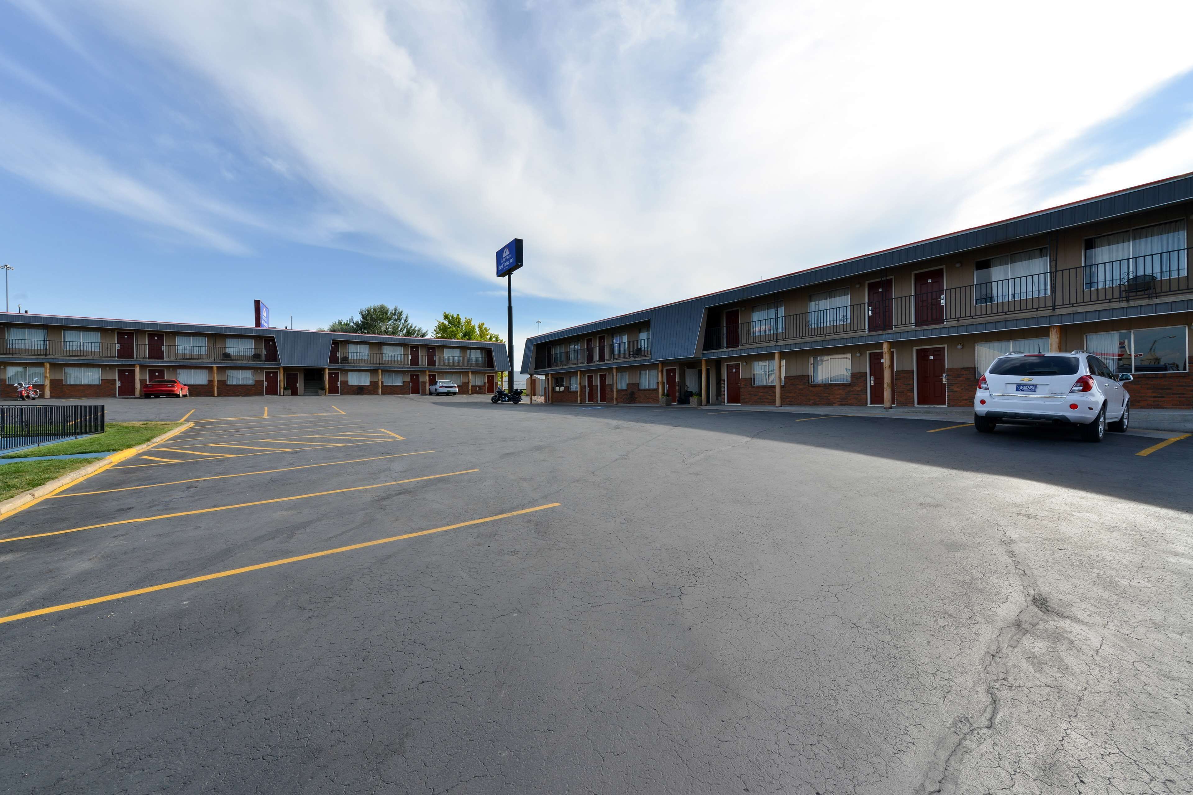 A motel with multiple rooms, a parking lot, and a sign indicating a pet-friendly policy.