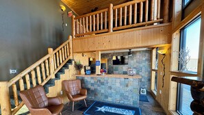 A lobby with a wooden staircase, a reception desk, and two leather chairs. - Americas Best Value Inn Wall (Wall)