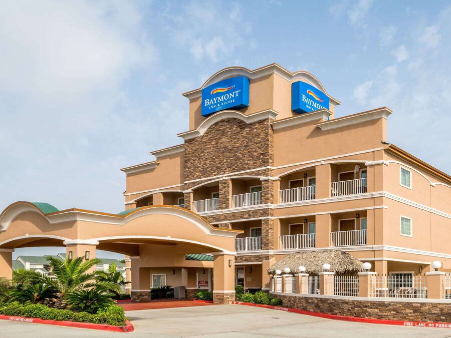 A Baymont Inn & Suites building with a two-story structure, multiple balconies, and a covered entrance area.