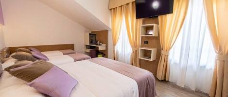 Habitación de hotel con dos camas, televisor y estante con artículos de aseo.