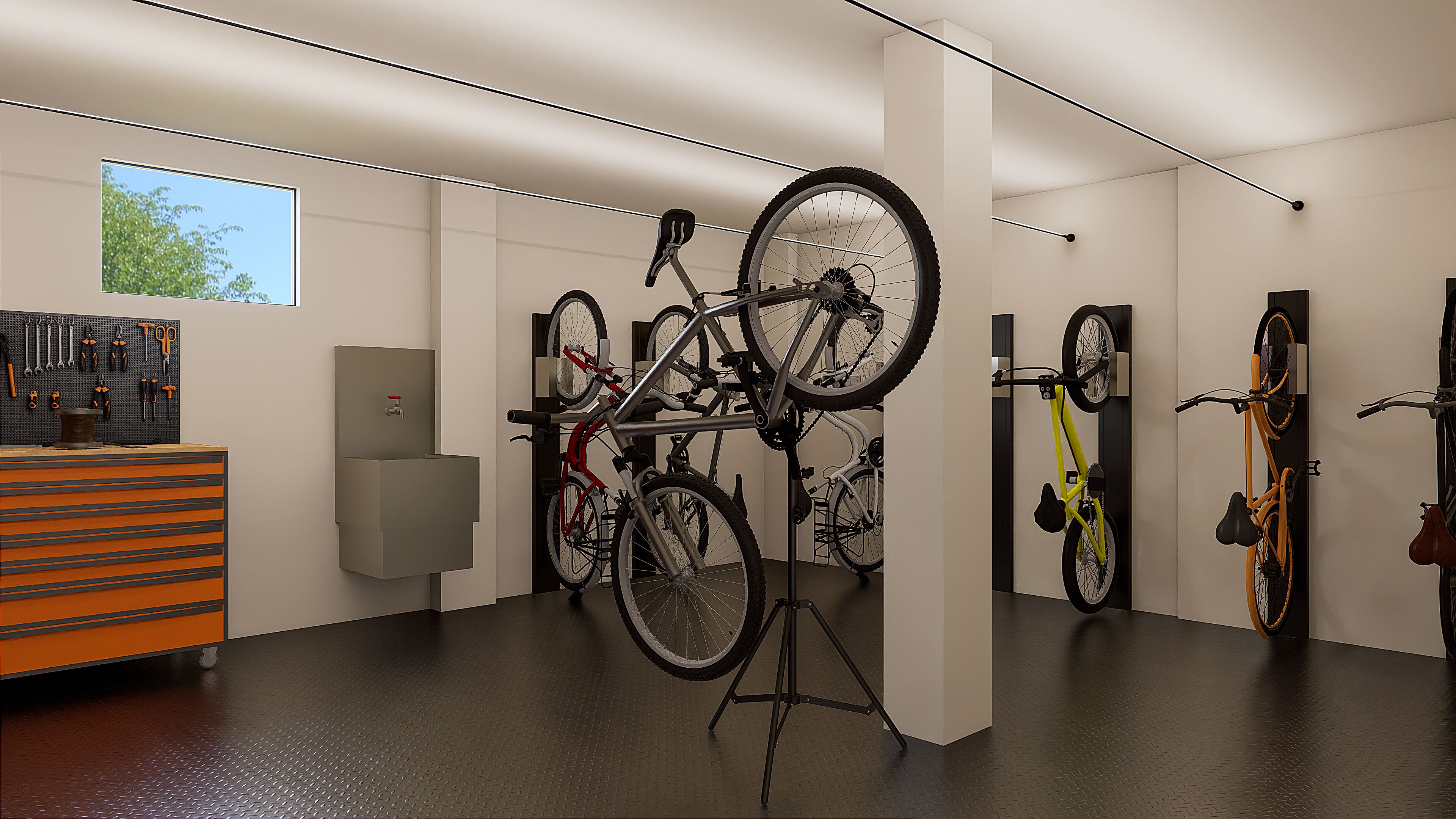 Habitació amb bicicletes penjades a la paret, un suport per eines i un rentapeus.