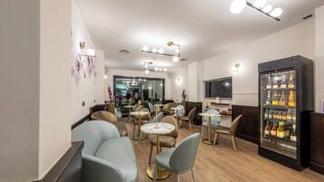 Een moderne lounge met zitplaatsen, een koelkast vol drankjes en een televisie.