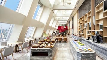 Un comedor moderno con techos altos, ventanas amplias y vistas a la ciudad.