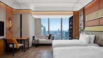A modern hotel room with a city view, a sofa, a desk, and a bed.