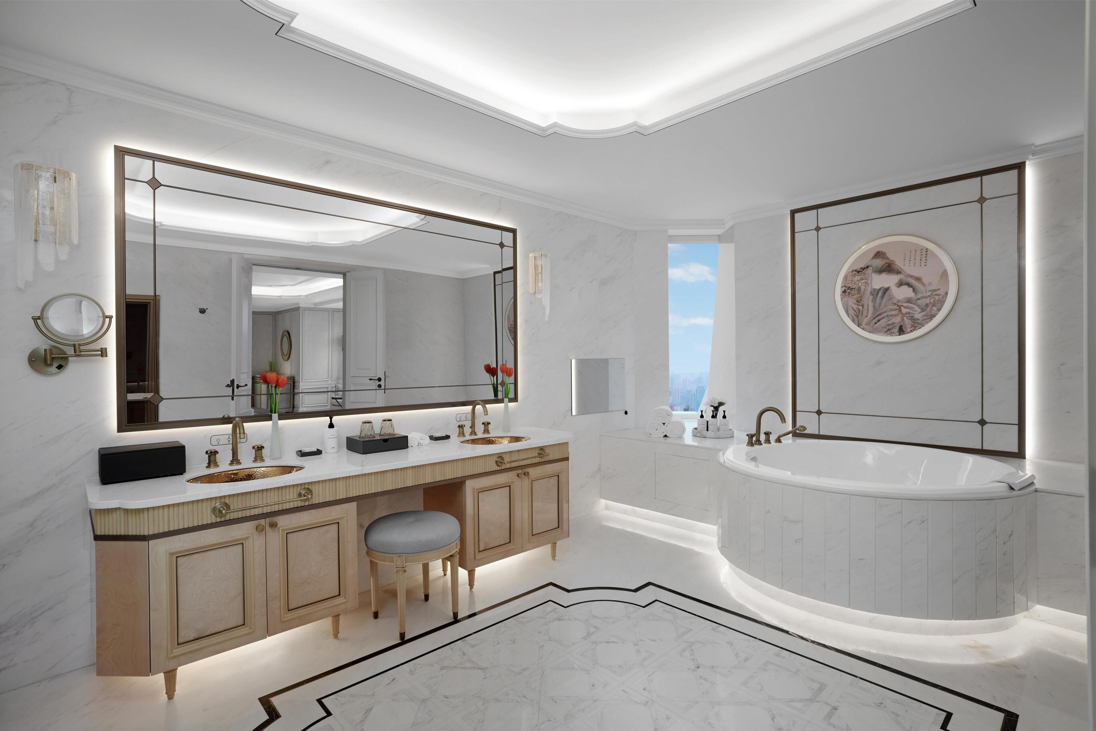A modern bathroom with a large mirror, dual sinks, a bathtub, and a marble floor.