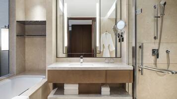 A modern bathroom with a bathtub, a large mirror, a vanity with a sink, and a shower area.