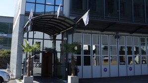 Ein modernes Hotel mit Glasfassade, einem gut sichtbaren Schild mit der Aufschrift "STANS SUD HOTEL" und einem überdachten Eingangsbereich.