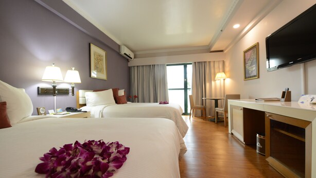 A hotel room with two beds, a desk, a TV, and a bathroom. - Days Inn Guam-Tamuning (Tamuning)