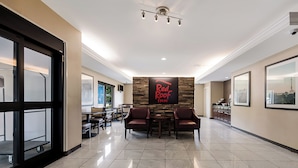 Un interior moderno con zona de comedor, asientos y una pared con un logotipo.