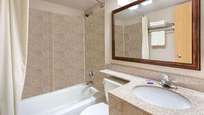 Un baño con una bañera, un lavabo y un espejo.