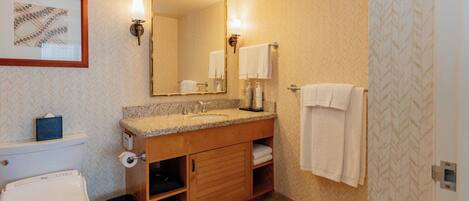 Une salle de bain comprenant des toilettes, un lavabo, un meuble-lavabo et un grand miroir.