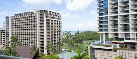 A high-rise hotel with multiple floors, balconies, and a view of the ocean.